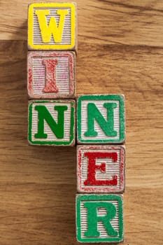 Vintage Wooden Childrens Blocks spell out the word Winner