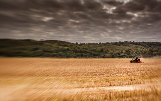 Tractor plowing the field in rural part of England