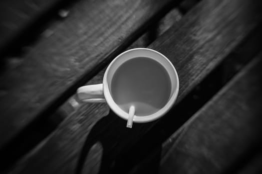 Unfinished coffee on a wooden table in an outdoor cafe