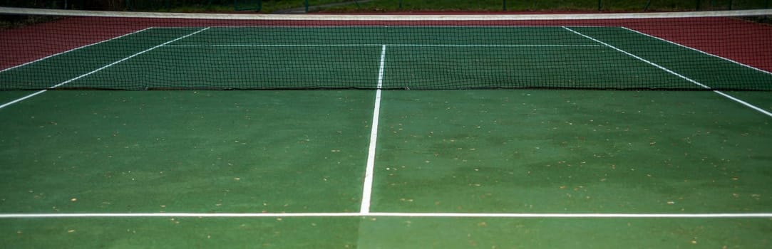 Empty tennis court available for the public, photographed in the evening
