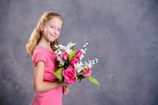 nice blond girl bouquet of flowers in front of gray background