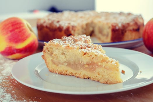 piece of apple pie with crumbles on wooden ground