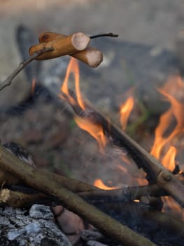 Frankfurters fried over open fire at a camping site in a wild