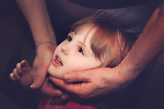 Grandmother holding her beloved granddaughter in her hands at the wedding reception
