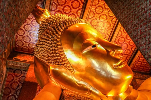 Head of the Reclining Budda in a temple in Bangkok,  Thailand