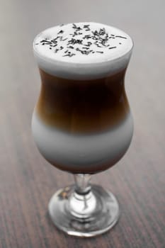Coffee latte with milk on wooden table.
