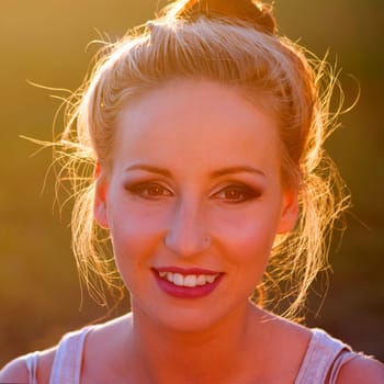Portrait about a smiling young woman at sunset.