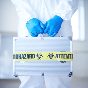 Close-up of medical case with biohazard symbol in scientist gloved hands