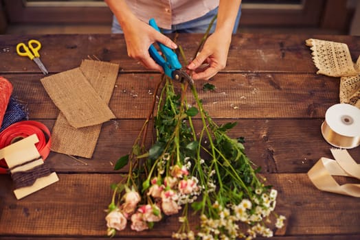 Florist trimming flowers with pruner
