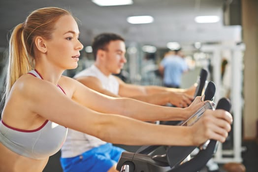 Portrait of young woman and man during workout in gym
