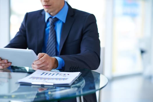 Young businessman using digital tablet at workplace