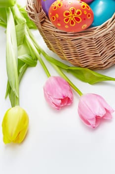 Composition of three fresh tulips and painted Easter eggs