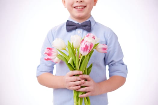 Little boy with bunch of fresh tulips