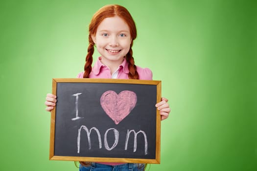 Pretty girl holding board with declaration of love to mother