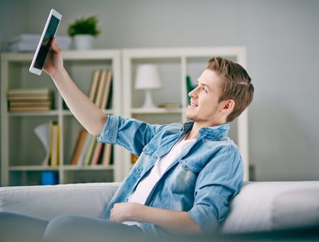 Young man taking self-portrait with touchpad