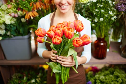 Female florist holding bunch of red tulips