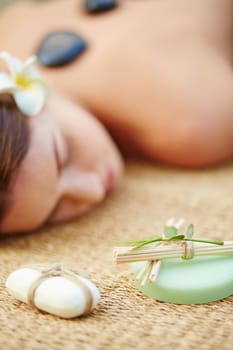 Toilet soap bars with cosmetic sticks and relaxed female on background
