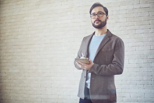 Young businessman making notes in notepad