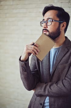 Pensive businessman with notepad brainstorming