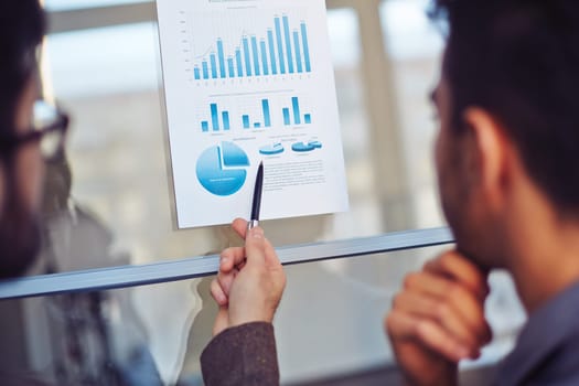 Businessman explaining document with charts and diagrams to his colleague