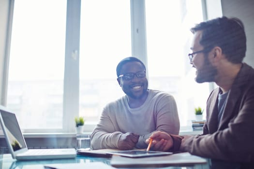 Asian and African employees discussing ideas in office