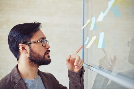 Young modern businessman pointing at reminder on board