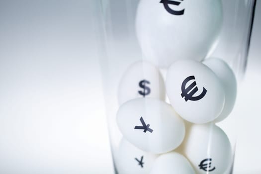 Close-up of eggs with currency signs in glass