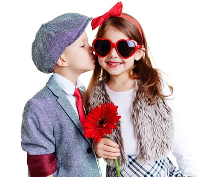 Portrait of well-dressed children, boy kissing a girl