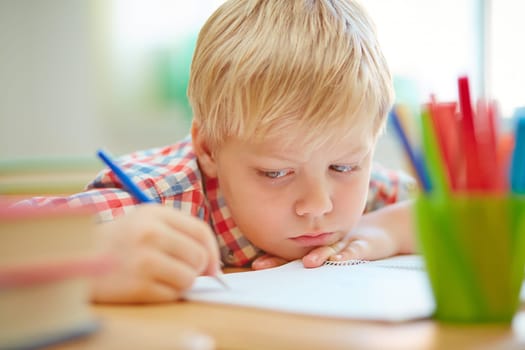 Serious learner making notes or drawing in exercise book