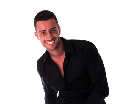Smiling young man in black shirt, looking at camera, isolated on white