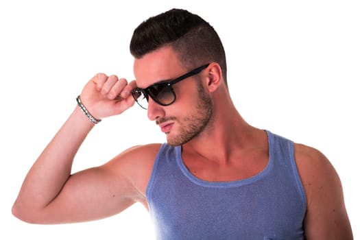 Cool confident young man with sunglasses and tank-top on white background