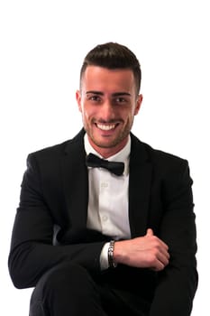 Handsome young man with suit and bowtie isolated on white, looking at camera