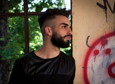 Handsome young man with beard looking to a side