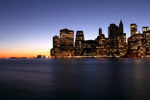 Twilight as the sun sets over Lower Manhattan. Famous New York landmarks.