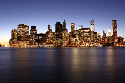 Twilight as the sun sets over Lower Manhattan. Famous New York landmarks.