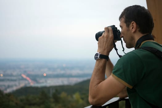 The tourist is taking picture with digital camera about the city landscape.