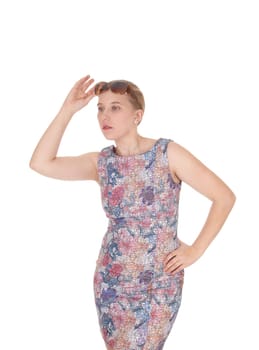 A beautiful young woman standing in a colorful dress with her .sunglasses on her forehead, isolated for white background.