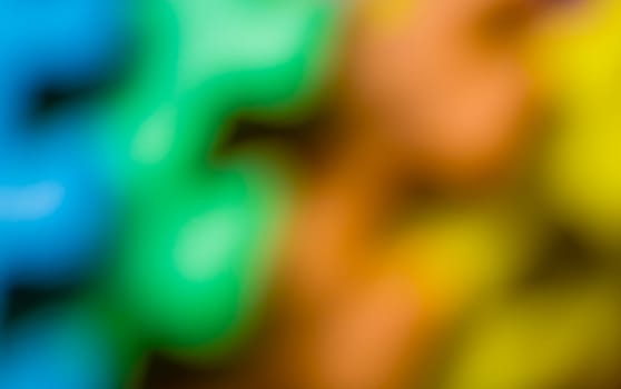 Defocused colorful pieces of a children's soft toy mat, colorful background