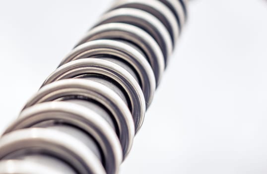 Close up of a twisting metal spiral over white background