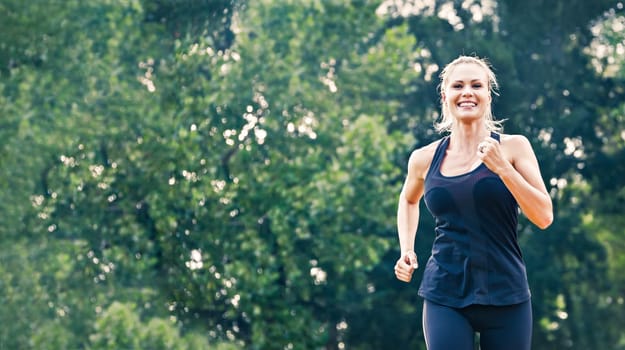 Blonde young woman running in the park