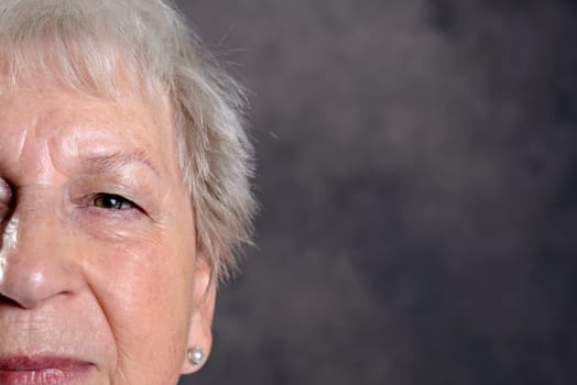 close up portrait of elderly woman in front of dark background