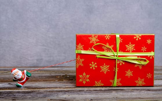 little Santa Claus pulling big red gift box