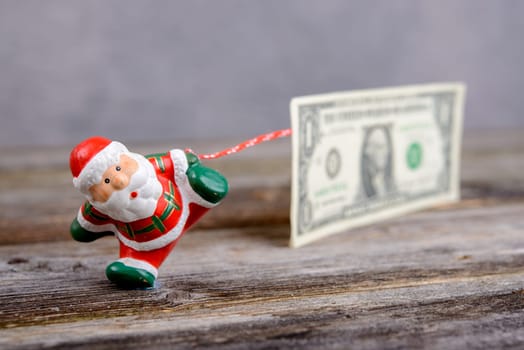 little Santa Claus pulling big euro banknote