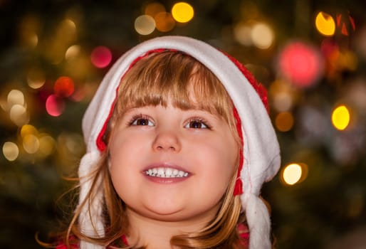 Cute Christmas girl with the Christmas tree in the background