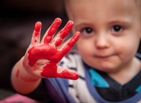 Child's hand with colored fingers from using paint