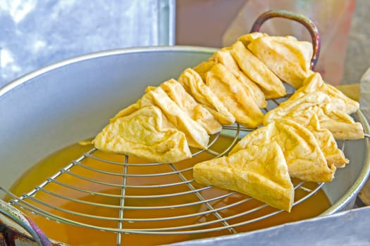 Fried tofu with hot oil on grille thai and chinese food.