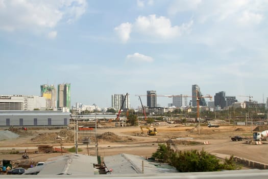 Inside place for many tall buildings under construction and cranes under a blue sky