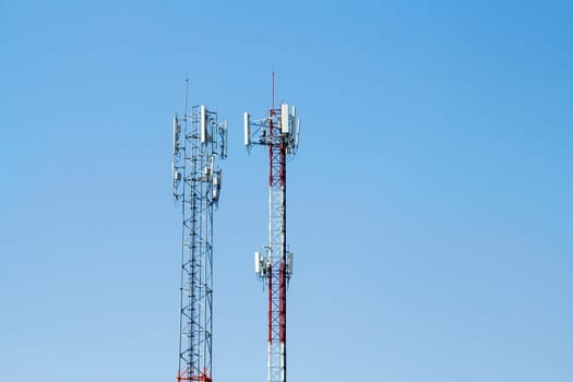 Mobile phone communication tower transmission  signal with blue sky background and antenna and twin