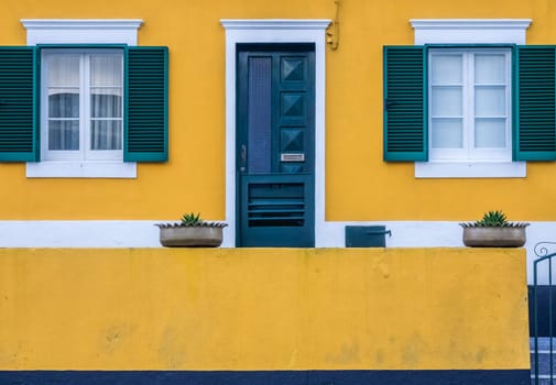 Colorful yellow and green home facade in Ponta Delgada, Sao Miguel, Azores, Portugal