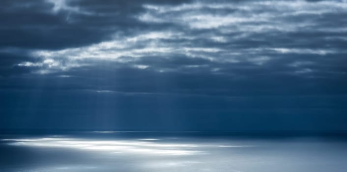Light rays and clouds over the sea before sunset
